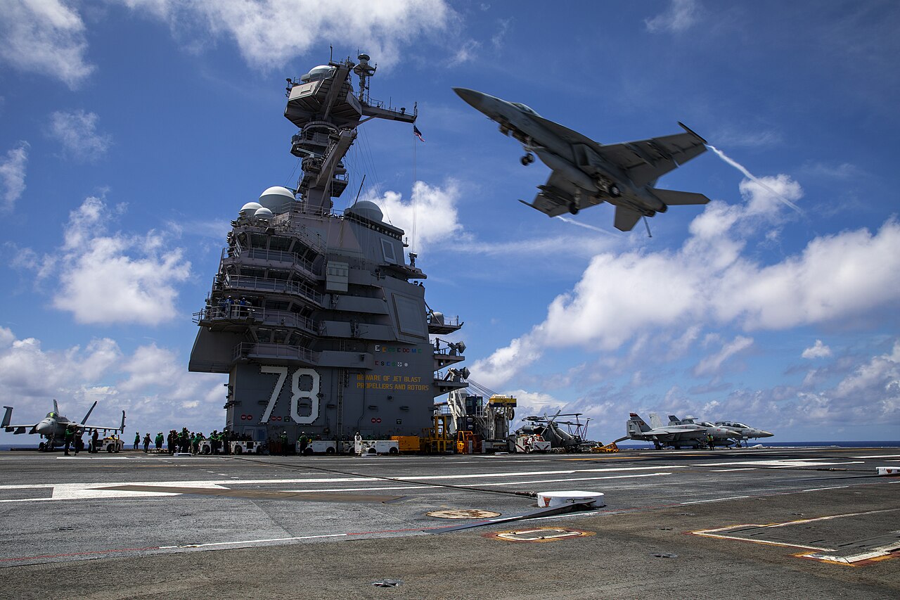 F/A-18E Super Hornet sobrevoa o CVN 78 USS Gerald R. Ford, primeira unidade da sua classe de navios. Foto: Jarrod Bury