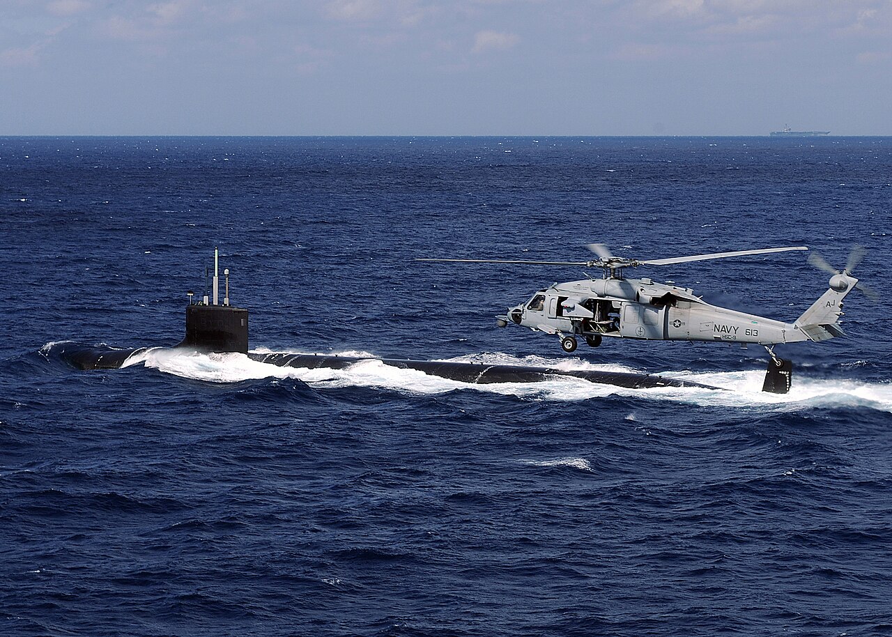 Submarino SSN 779 USS New Mexico próximo de um helicóptero H-60S Sea Hawk do porta-aviões USS George H.W. Bush (CVN 77). Foto Nicholas Hall